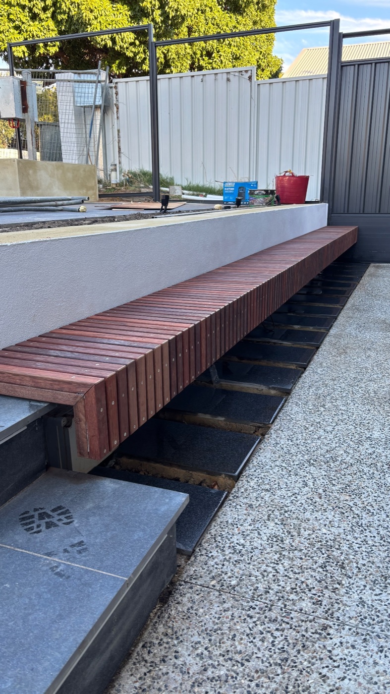 Custom timber bench seating over a water feature by Westsite Build Co.